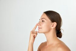 A woman pointing to her nose