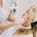 Skilled,Beautician,Performing,Chin,Augmentation,On,Female,Patient,,Lying,Relaxed